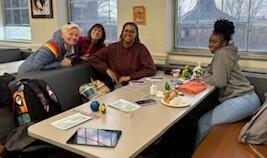 Students gather around table with professor