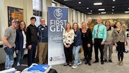 First Gen committee members stand around sign