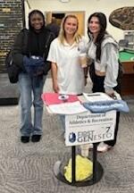 Students stand around table