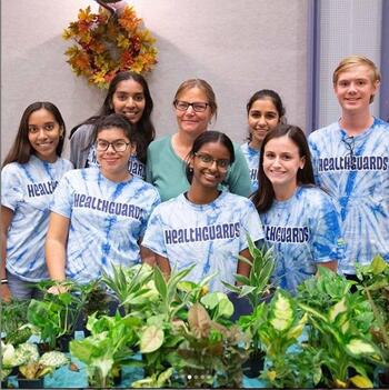 Health Promotion Coordinator Dana Minto with group of 7 Healthguards in blue shirts