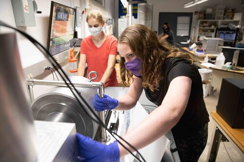 Two female students work in a physics lab.