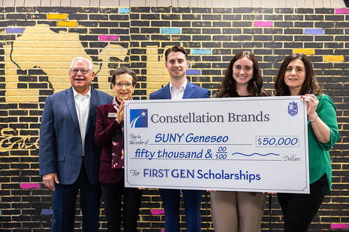 Image of large check held by constellation brands inc employees and President Denise A. Battles Battles.