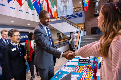 Lieutenant Governor Antonio Delgado shakes hands with a student while President Battles looks on