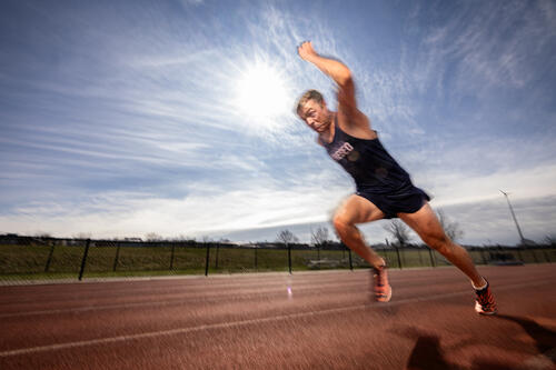 Lance Jensen '24 runs on the track with dramatic lighting