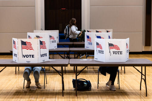 Students fill out ballots behind the privacy screens