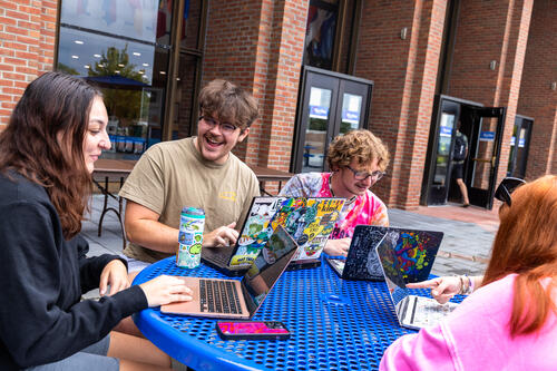 Student Orientation leaders talk at a table.