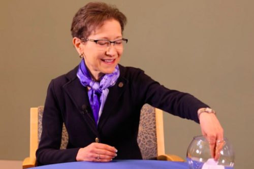 President Denise Battles choosing a question printed on a piece paper from a bowl.