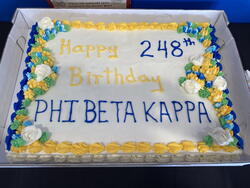 Sheet cake with white icing and yellow and blue decorations; lettering reads "Happy 248th Birthday Phi Beta Kappa"